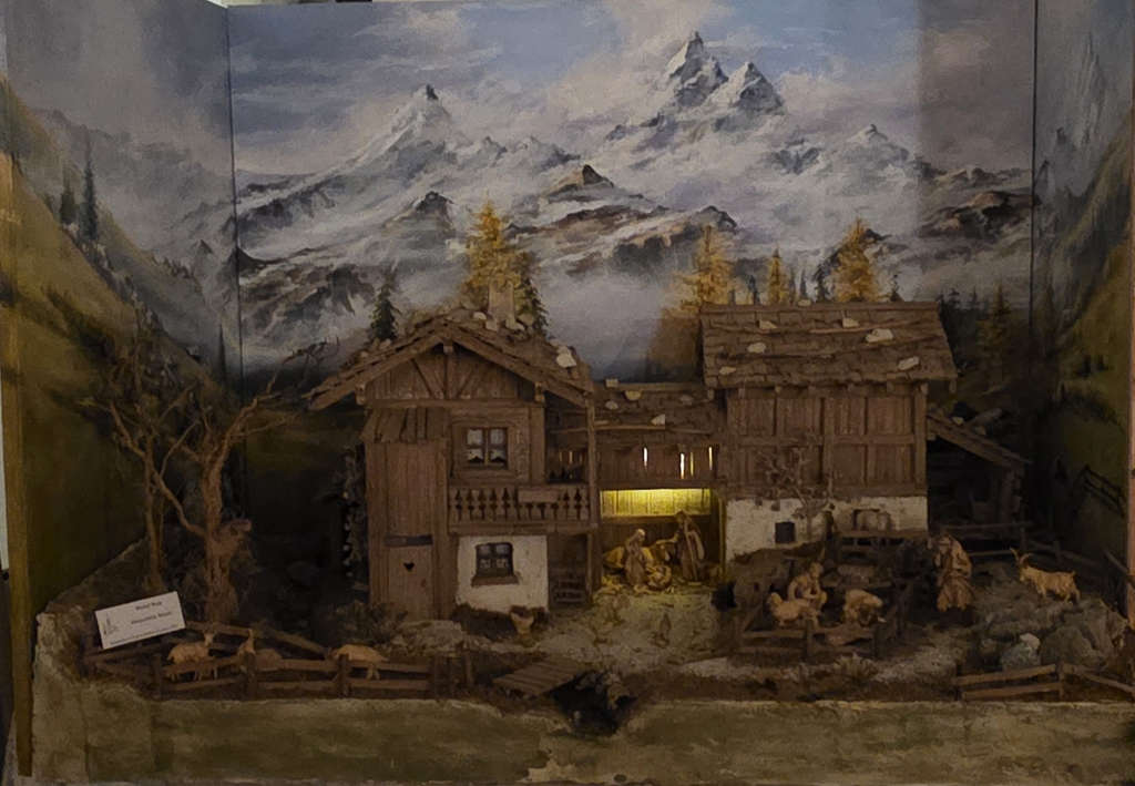 Heimatliche Krippe vor gemaltem Alpenpanorama